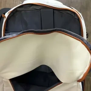 Detalhe da abertura e do forro da mochila branco e marrom