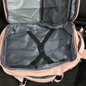 Mochila rosa com compartimento principal aberto e faixas de fixação